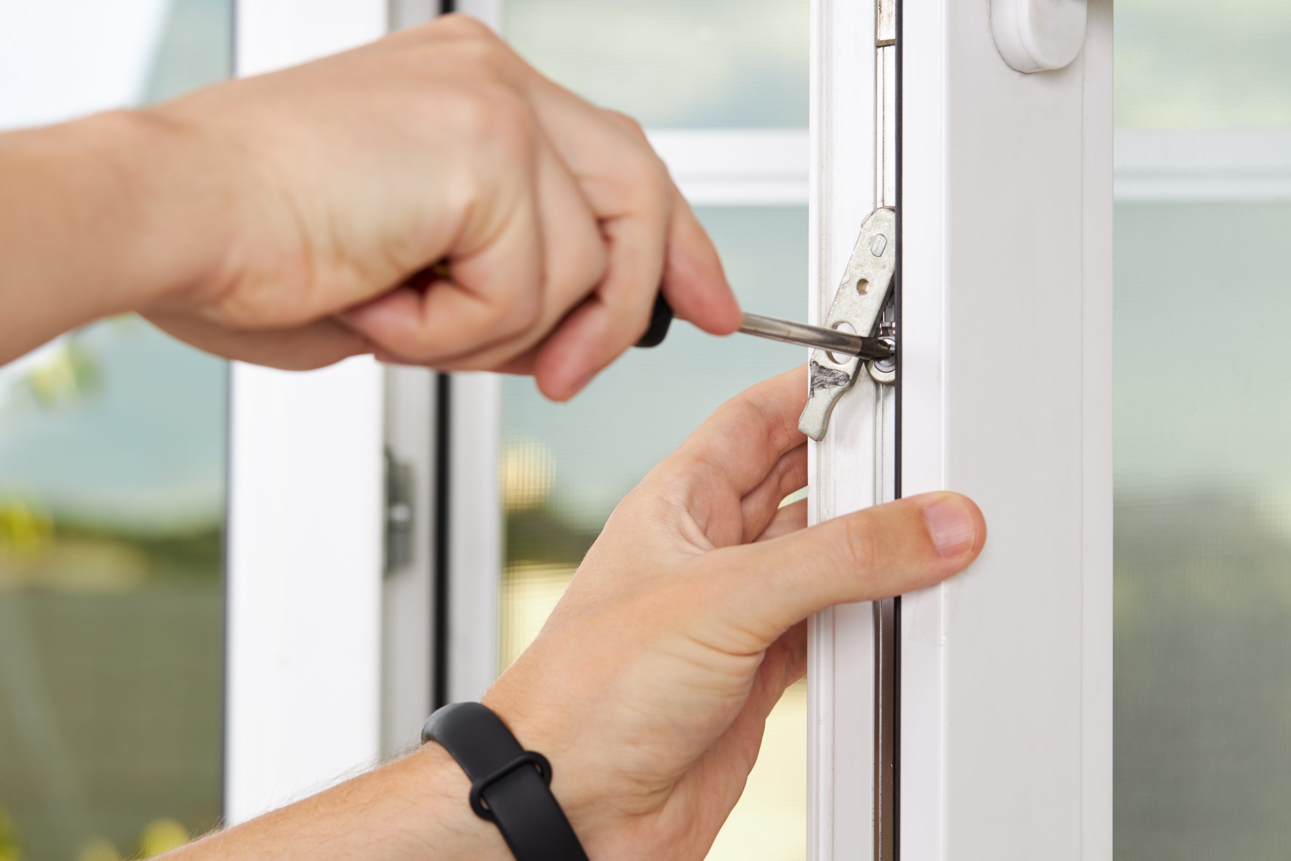 handyman adjusting white pvc plastic window