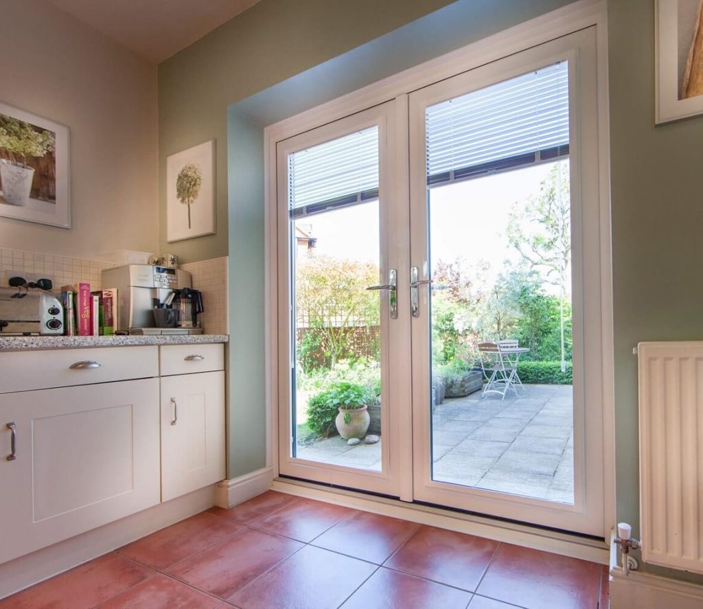 Interior kitchen view with cabinets, books, and a French door.