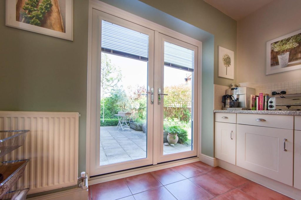 Interior kitchen view with cabinets, books, and a French door.
