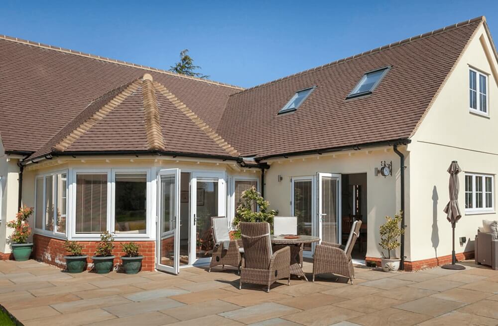 White French doors on a beige house with a patio and outdoor dining set