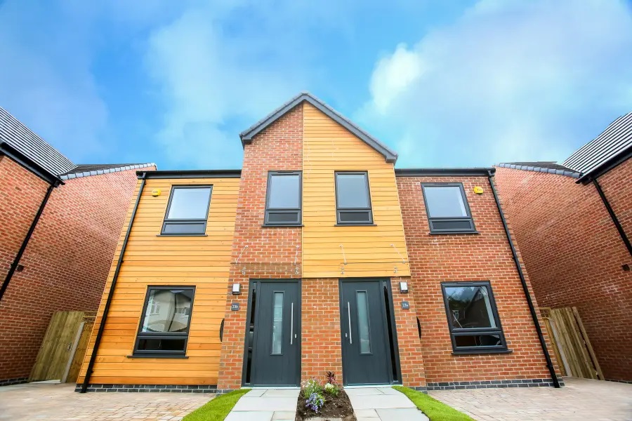 Modern semi-detached house with black uPVC casement windows and composite front doors.